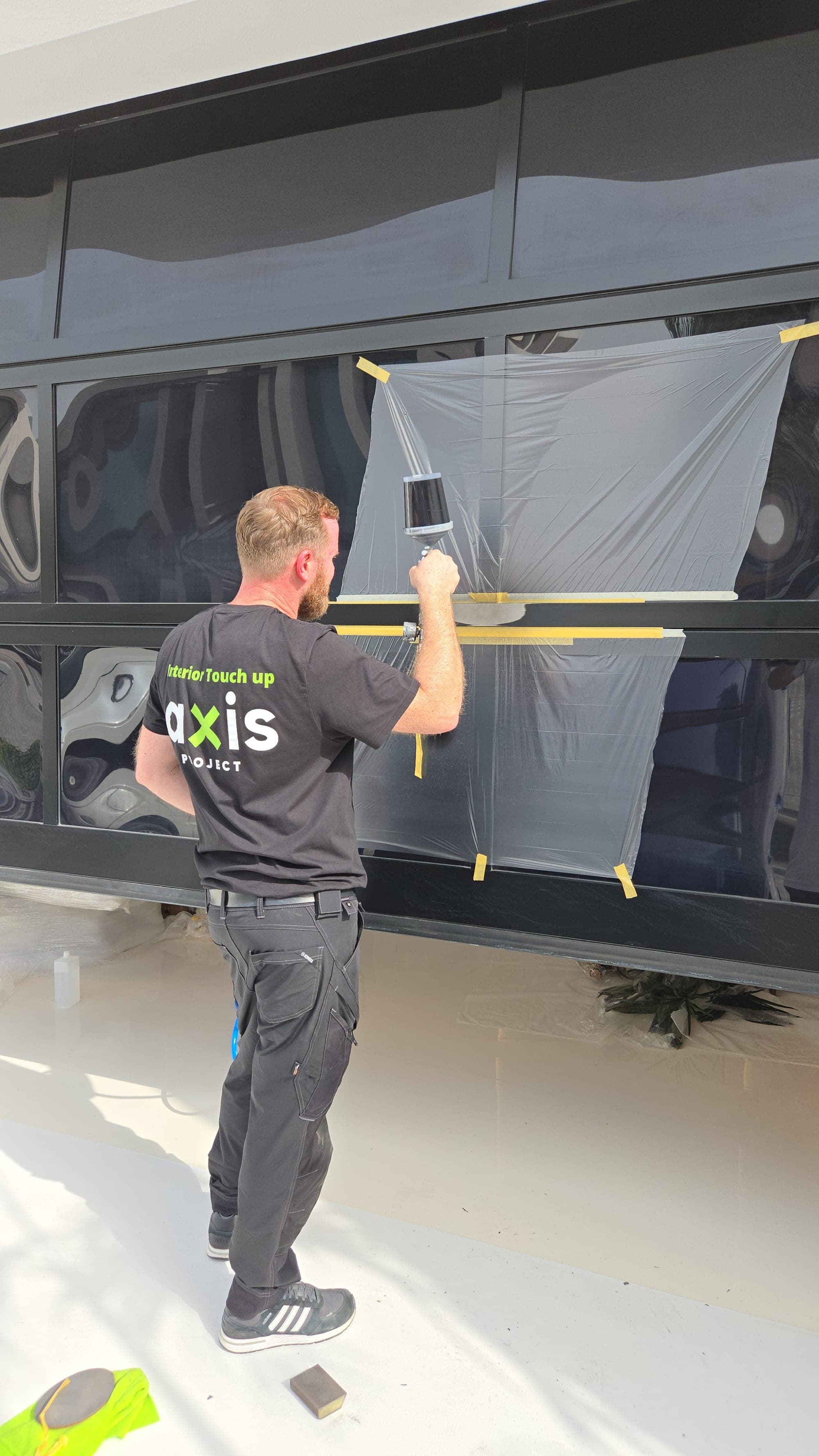 Axis Project specialist refinishing an aluminium door on site in Dubai